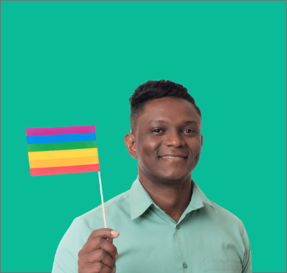 Vale's employee smiles to the photo while he holds a flag with LGBTI+ colors