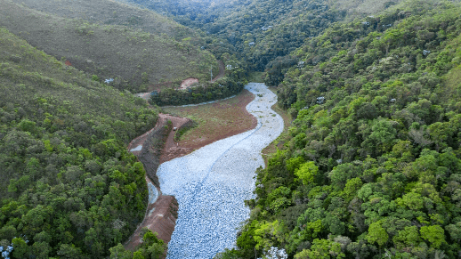 Rio cruzando montanha coberta por árvores