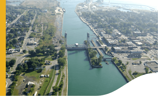 Vista aérea de Port Colborne, nos cantos da imagem é possível ver uma cidade bastante arborizada. No meio há a passagem de um rio e uma ponte ligando ambos os lados.