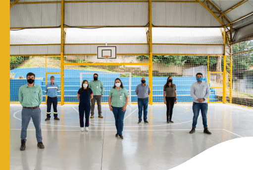 Eight people, among them Vale employees, are on a sports court. Everyone is far from each other and wearing a protective mask.