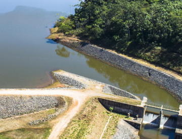 Photo of a dam eliminated with stones, a river, earth path and vegetation around it